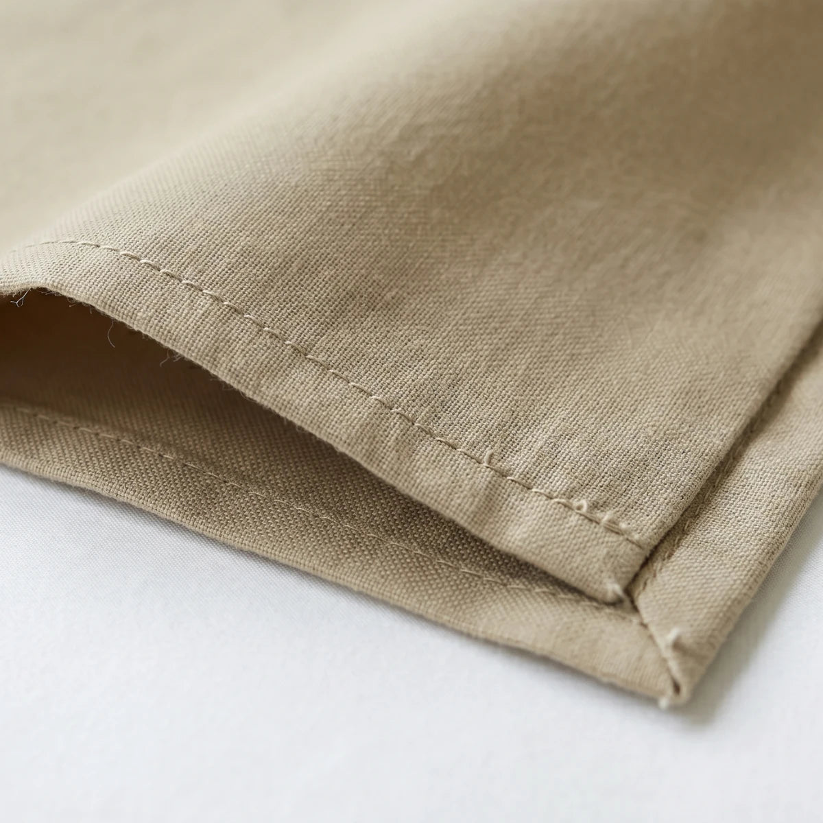 Close-up of Ivory Sand Beige T200 cotton percale fabric weave and hemstitch detail showing matte finish