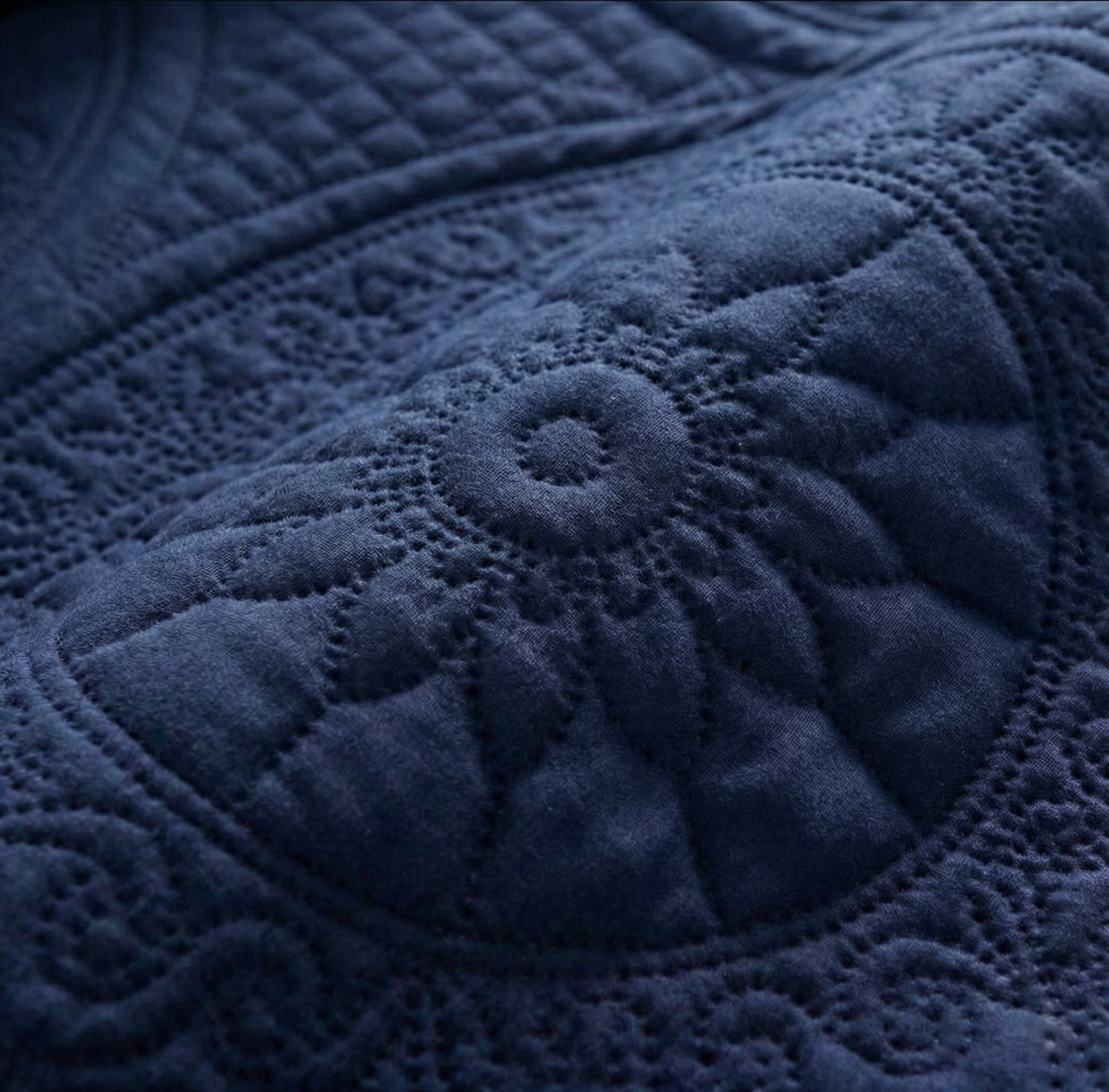Close-up of a textured blue fabric of a bedsheet with a circular pattern