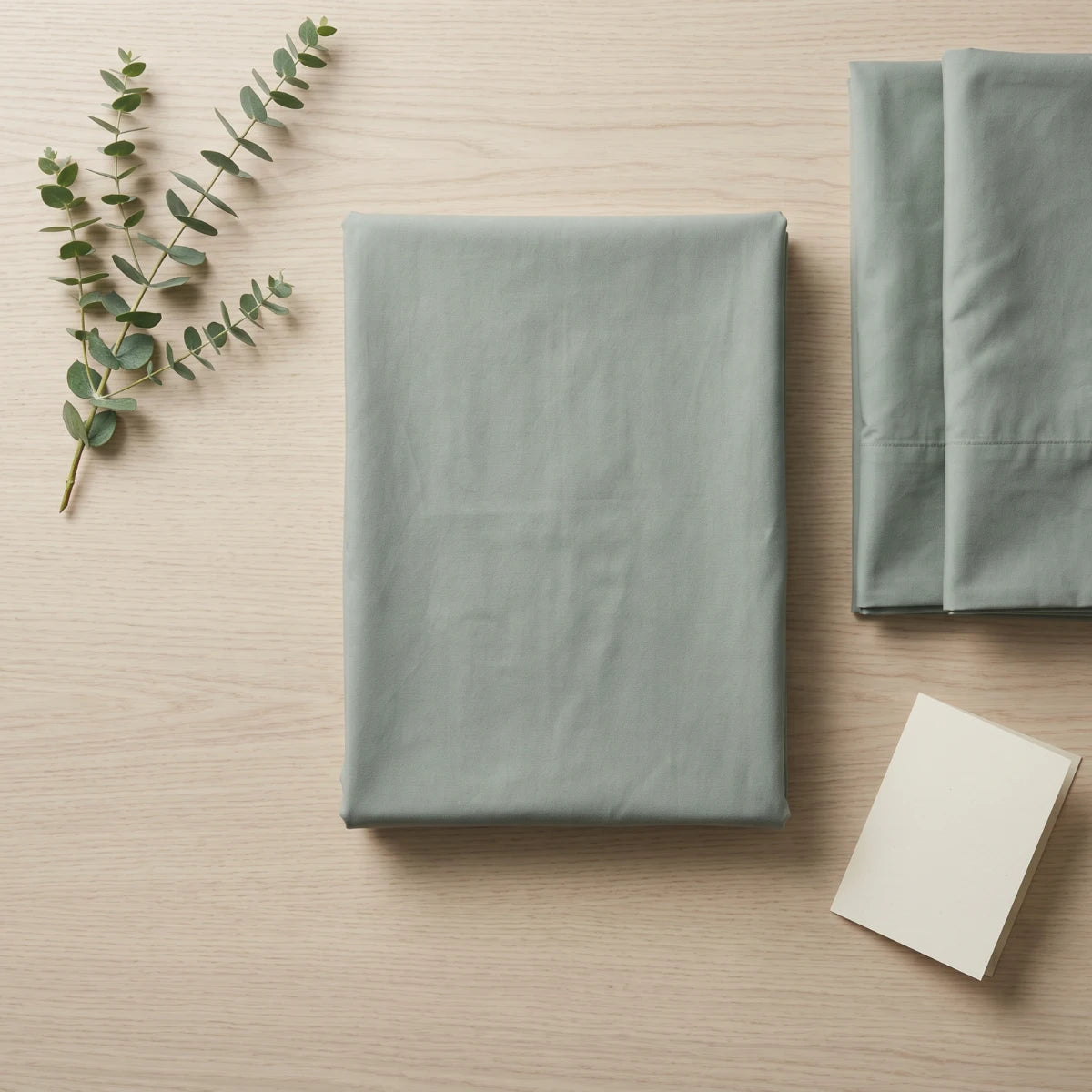 Sage Mist Green T200 cotton percale flat bedsheet set folded with eucalyptus by LuxeCotton Pakistan

