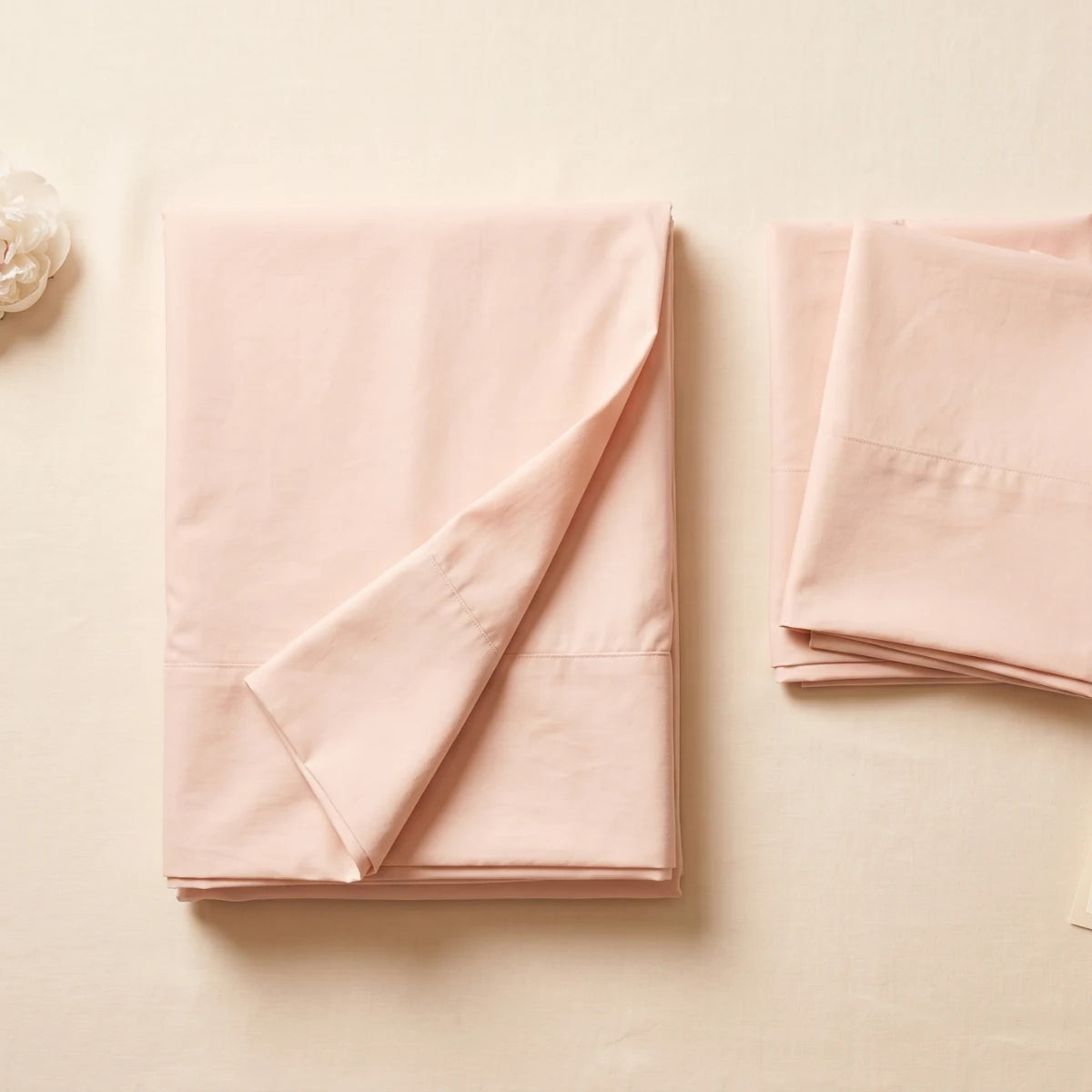 Pink T200 cotton percale flat bedsheet set folded with white peony by LuxeCotton Pakistan