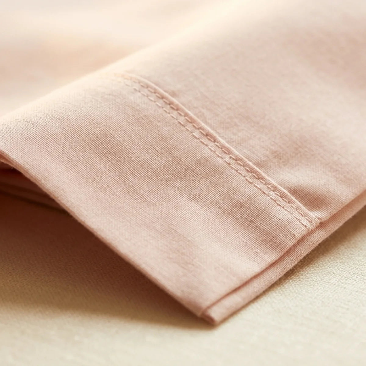 Close-up of Pink T200 cotton percale fabric weave and hemstitch detail showing matte finish